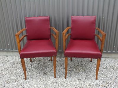 deux fauteuils en cuir rouge placés l'un à côté de l'autre devant un mur métallique