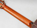underside view of an acoustic guitar with a wooden neck and frets