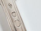 a close up of a silver spoon on a white surface