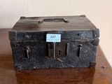 une vieille valise posée sur une table, avec une étiquette dessus
