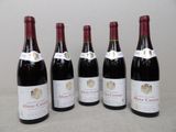 six bouteilles de vin rouge sont alignées sur une table