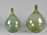 two green glass vases sitting next to each other on a table