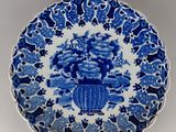 a blue and white plate with flowers on it sitting on a table