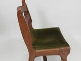 chair made of wood with a green velvet seat and back