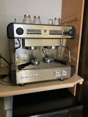 une machine à café posée sur une étagère à côté d'un réfrigérateur