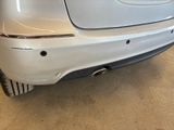 the rear end of a silver car in a showroom