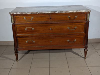 a marble top chest of drawers in the corner of a room
