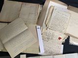 a pile of old papers sitting on a table next to a laptop