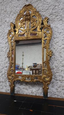 un miroir accroché au mur dans lequel on voit le reflet d'un bateau