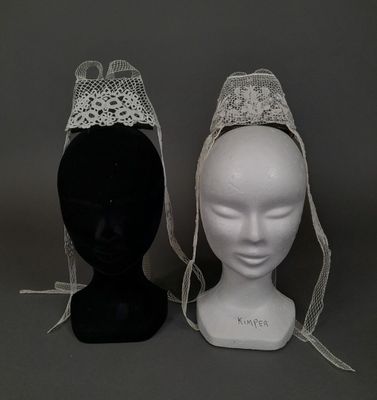 deux têtes de mannequin coiffées de chapeaux en dentelle