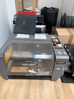 a printer that is sitting on the floor next to boxes