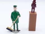 two figurines of a man with a broom and a man with a mop