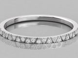 a white gold wedding band with diamonds on a reflective surface