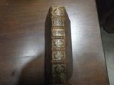 un vieux livre posé sur une table sur laquelle se trouve une horloge