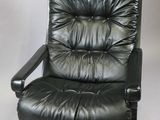 black leather reclining chair with black metal frame and foot rest