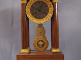une horloge posée sur un support sur une table