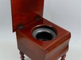 a small wooden toilet with a wooden seat on it
