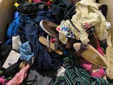 a box full of clothes and shoes sitting on the floor