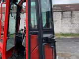 a red and black forklift parked in a parking lot