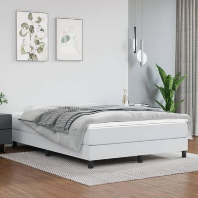 a white bed sitting in a bedroom next to a night stand
