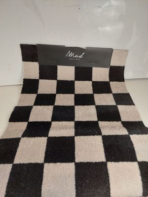 La couverture à carreaux noirs et blancs est posée sur la table.