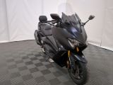 une photo d'une moto noire garée sur un sol à carreaux