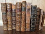 de nombreux livres anciens alignés sur une table en bois