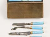 three knives and a knife sharper in a box on a white surface