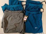 three pairs of men ' s under armour shorts on a table