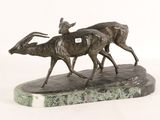 statue of two antelope running on a marble base on a white background
