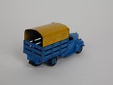 a blue toy truck with a yellow top on a white surface