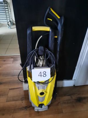 un aspirateur jaune et noir posé sur un parquet