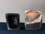 two pieces of pottery sitting next to each other on a table
