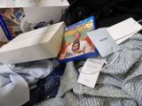 a pile of books and dvds on a bed