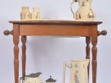 a wooden table with a shelf holding a tea pot and two mugs