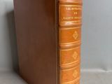a brown leather book sitting on top of a table next to a wall