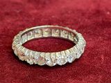 a close up of a diamond ring on a red velvet surface