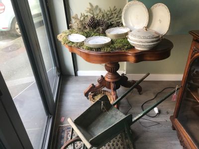 a table with a wheelbarrow and plates on top of it