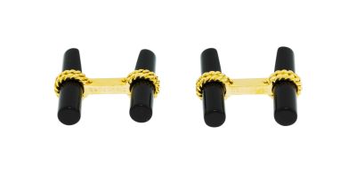 une paire de boutons de manchette noirs et dorés sur fond blanc
