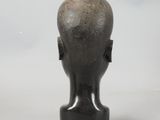 a black sculpture of a man ' s head on a white surface