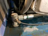 a hose connected to a water heater on the floor