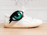 a close up of a pair of shoes with green eyes on them