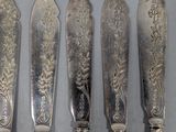 a lot of silver spoons and knives on the table