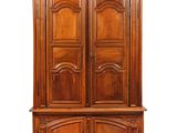 une grande armoire en bois à deux portes et deux tiroirs