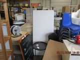 a refrigerator in the middle of a room with a stack of boxes