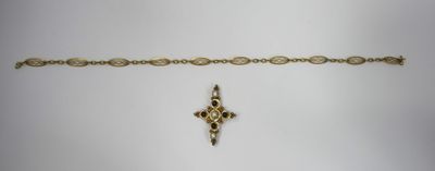 a close up of a gold bracelet with a cross on it