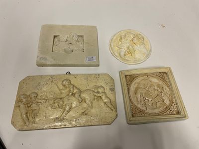four pieces of art on display on a white table