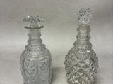 paire de bouteilles anciennes en verre taillé, munies de bouchons sur le dessus