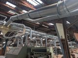 a machine that is working on a piece of wood in a factory