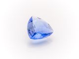 a close up of a blue diamond on a white surface